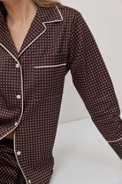 Brown patterned pajama top with white trim on a neutral background