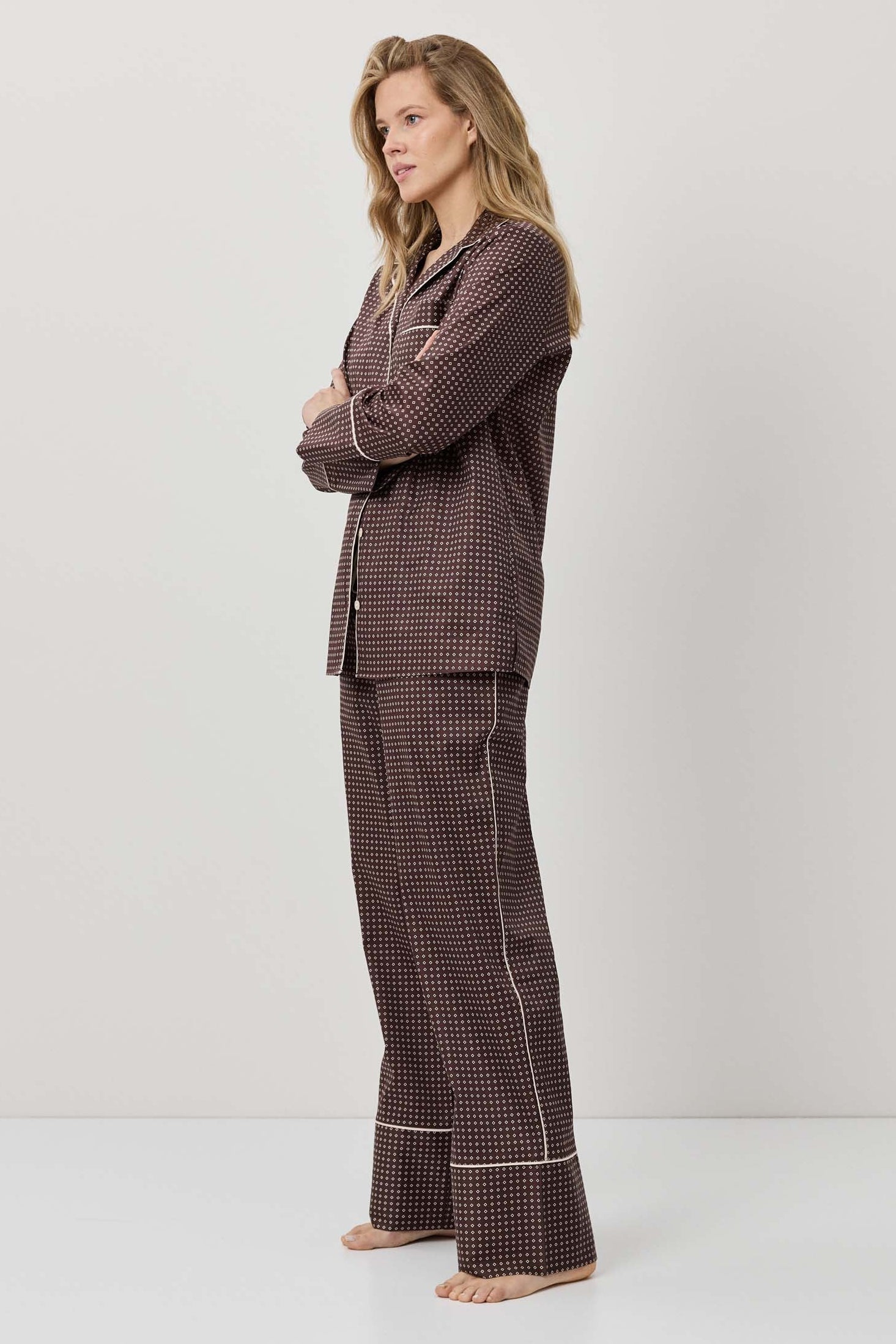 Woman wearing a brown checkered pajama set on a white background