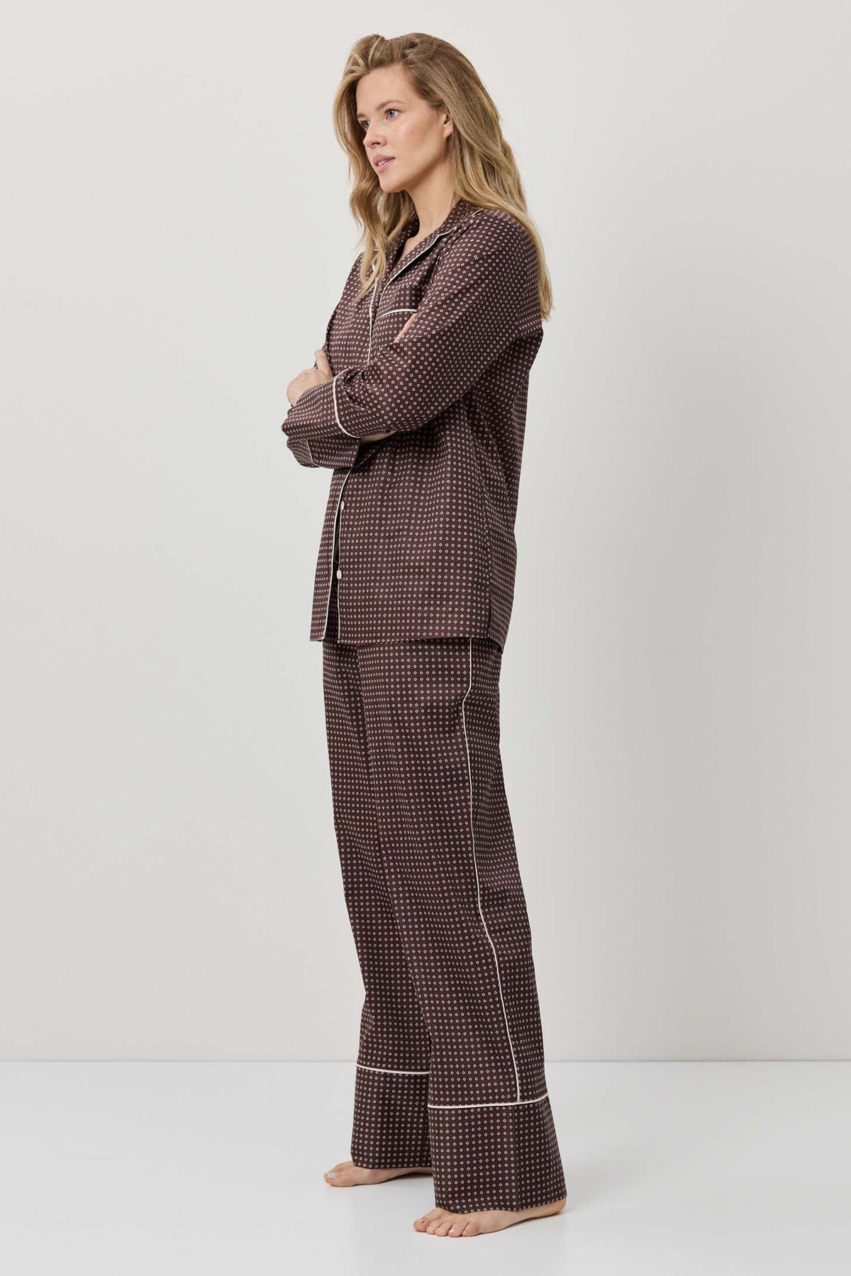 Woman wearing a brown checkered pajama set on a white background