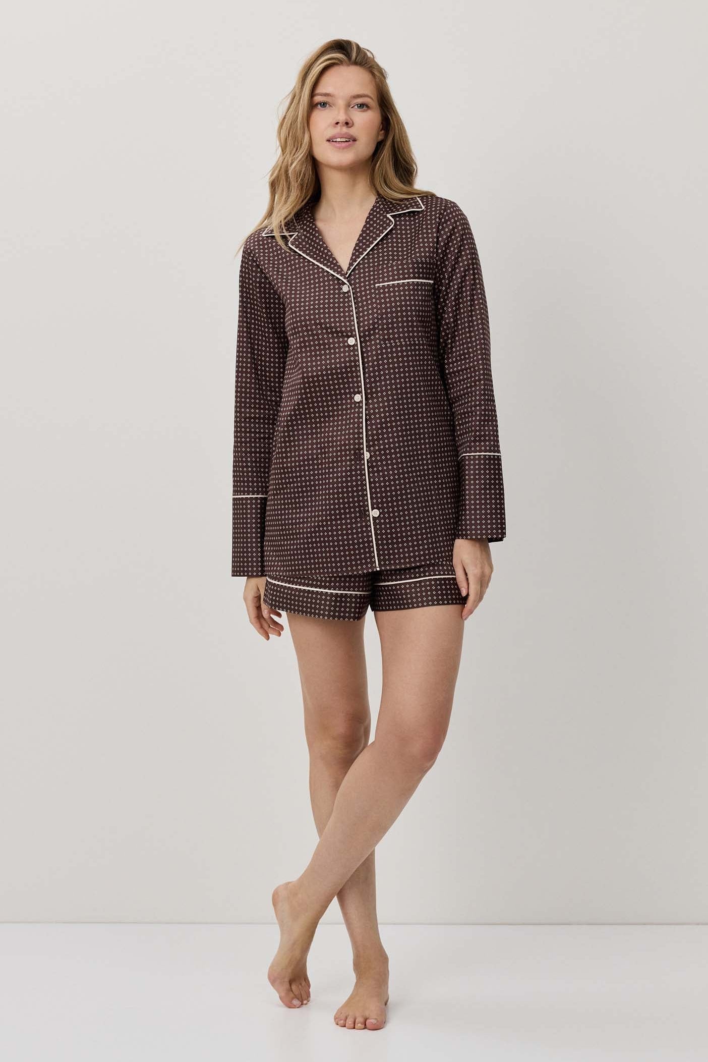 Woman wearing a brown checkered pajama set on a white background