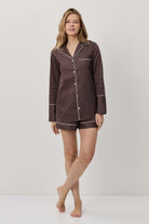 Woman wearing a brown checkered pajama set on a white background