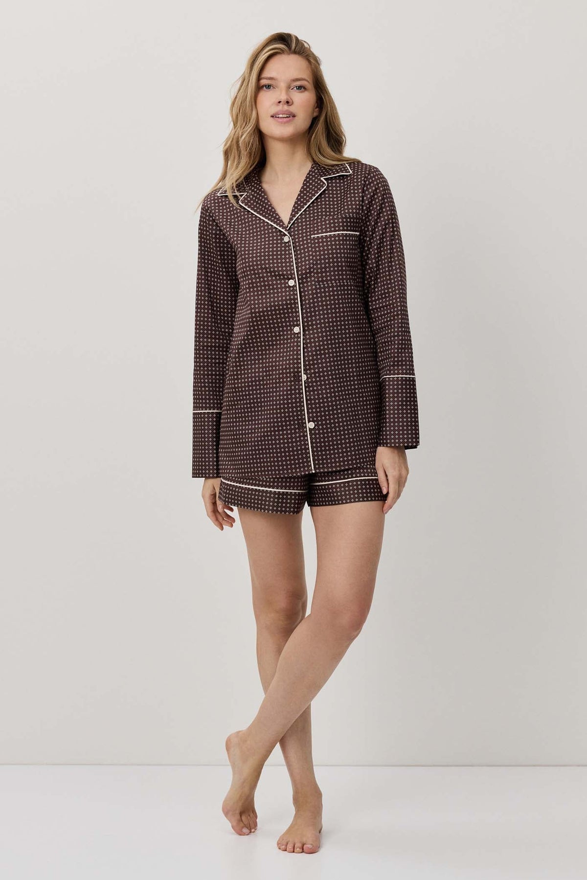 Woman wearing a brown checkered pajama set on a white background
