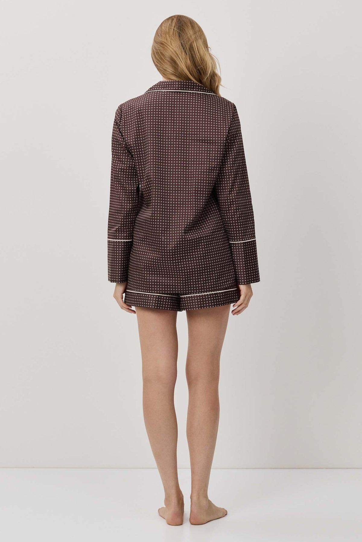 Person wearing a brown checkered outfit on a white background