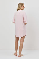 Person wearing a pink nightdress against a white background