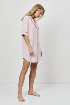 Woman wearing a pink nightshirt on a white background