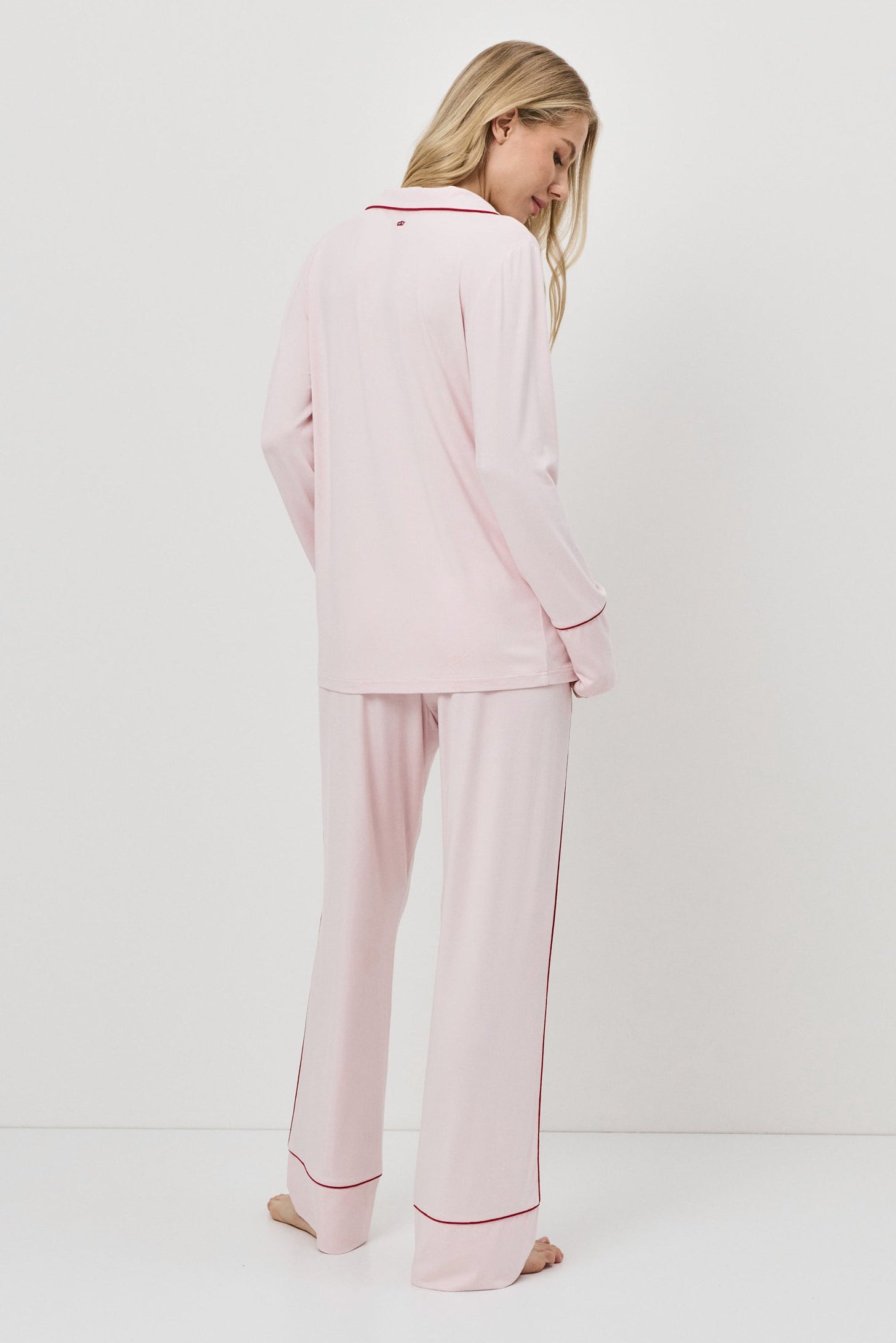 Woman wearing pink pajamas with a white background