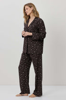 Woman wearing a dark floral pajama set on a white background