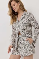 Woman wearing a leopard print outfit on a plain background
