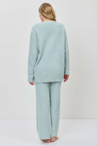 Person wearing a light blue outfit on a white background