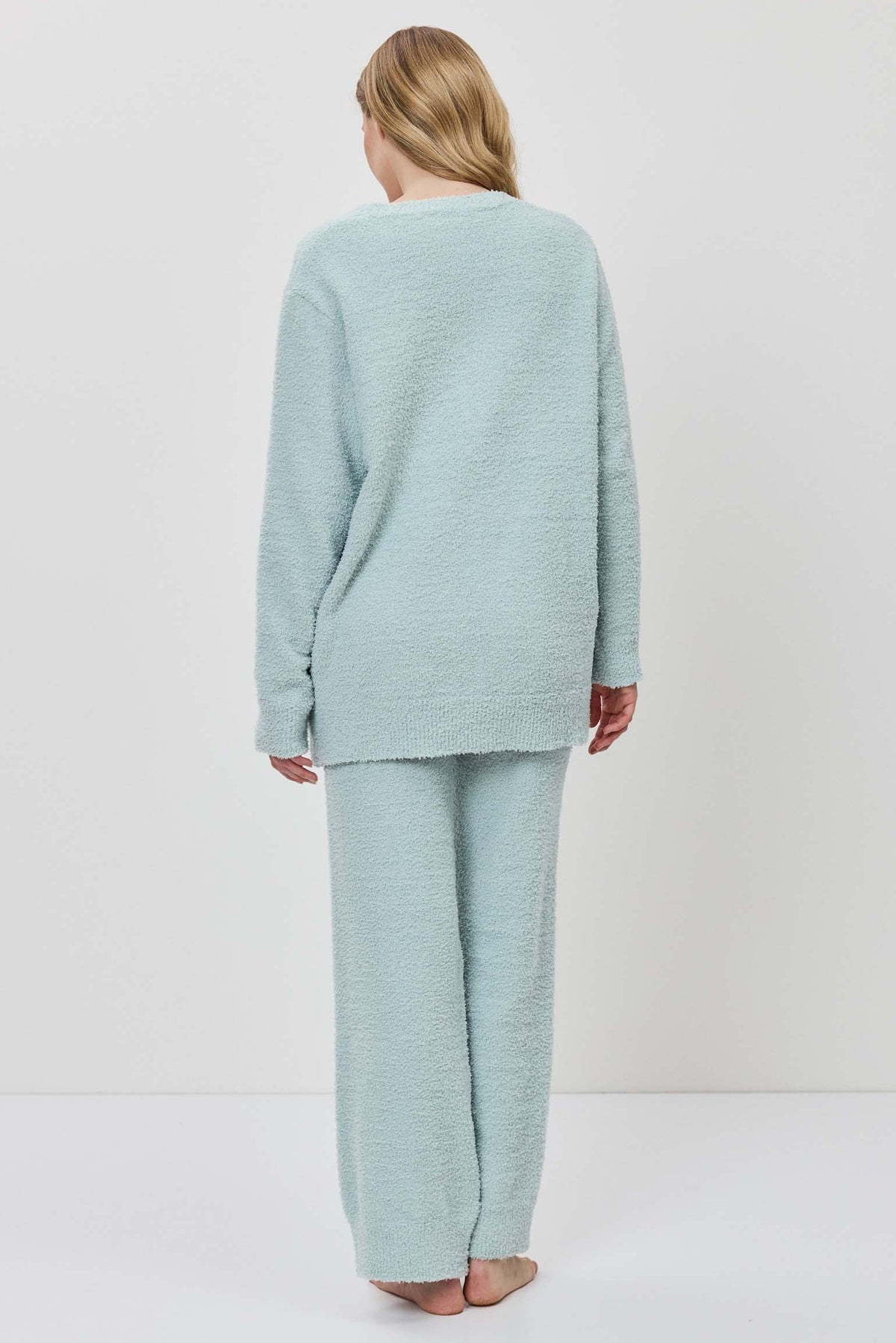 Person wearing a light blue outfit on a white background