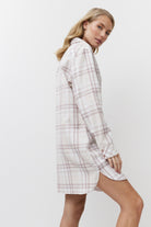 Woman wearing a plaid shirt dress on a white background