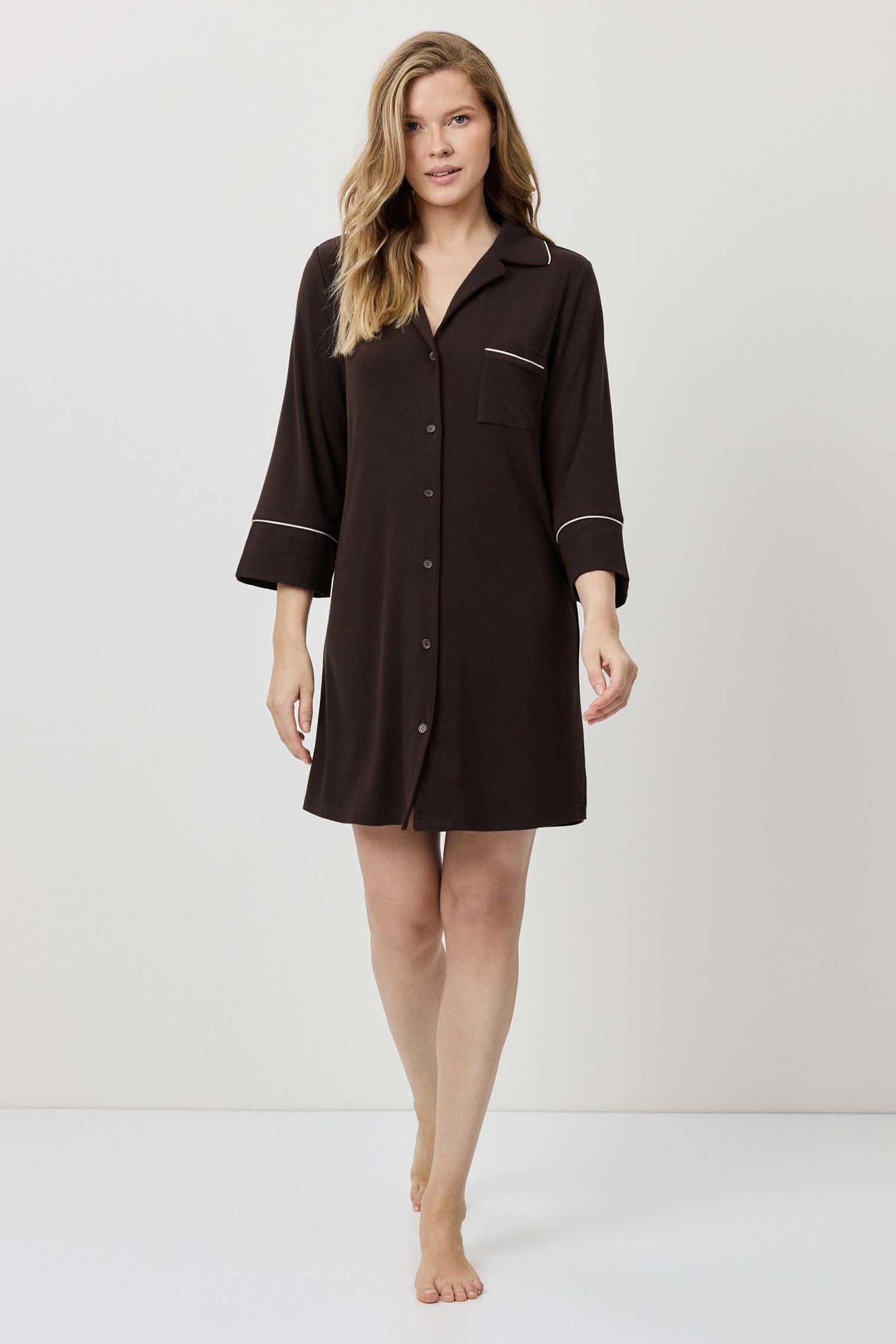 Woman wearing a brown nightshirt against a white background
