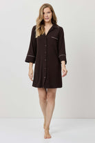 Woman wearing a brown nightshirt against a white background