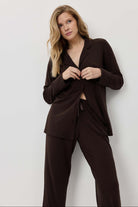 Woman wearing a brown suit against a white background
