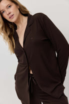 Woman wearing a brown suit against a plain background