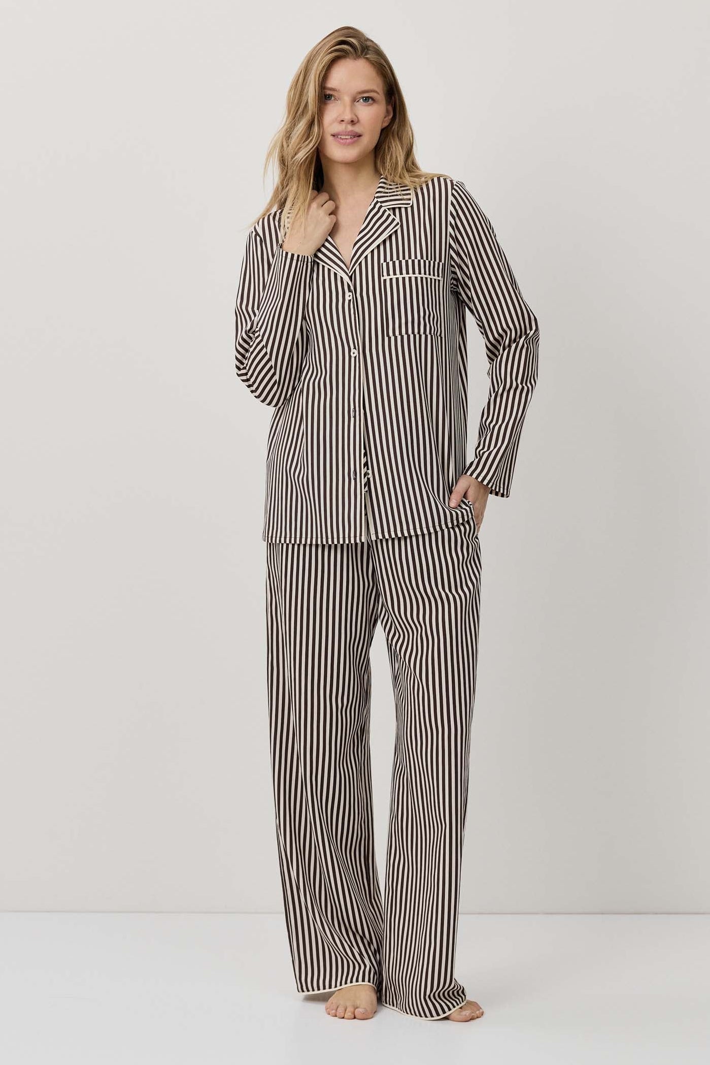 Woman wearing a striped pajama set on a white background