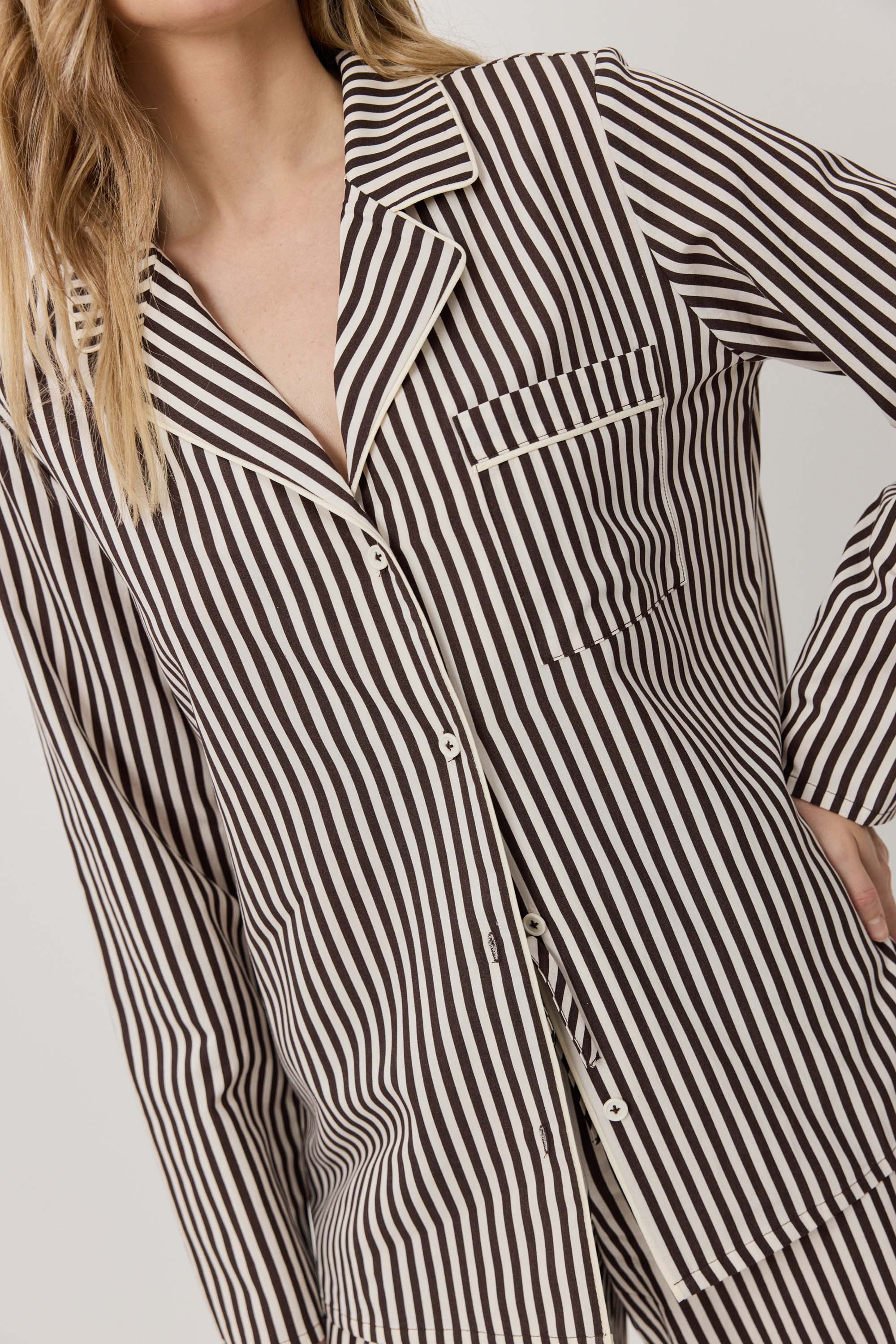 Black and white striped shirt worn by a person on a plain background