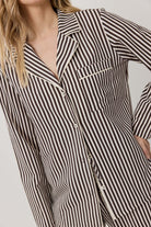 Black and white striped shirt worn by a person on a plain background