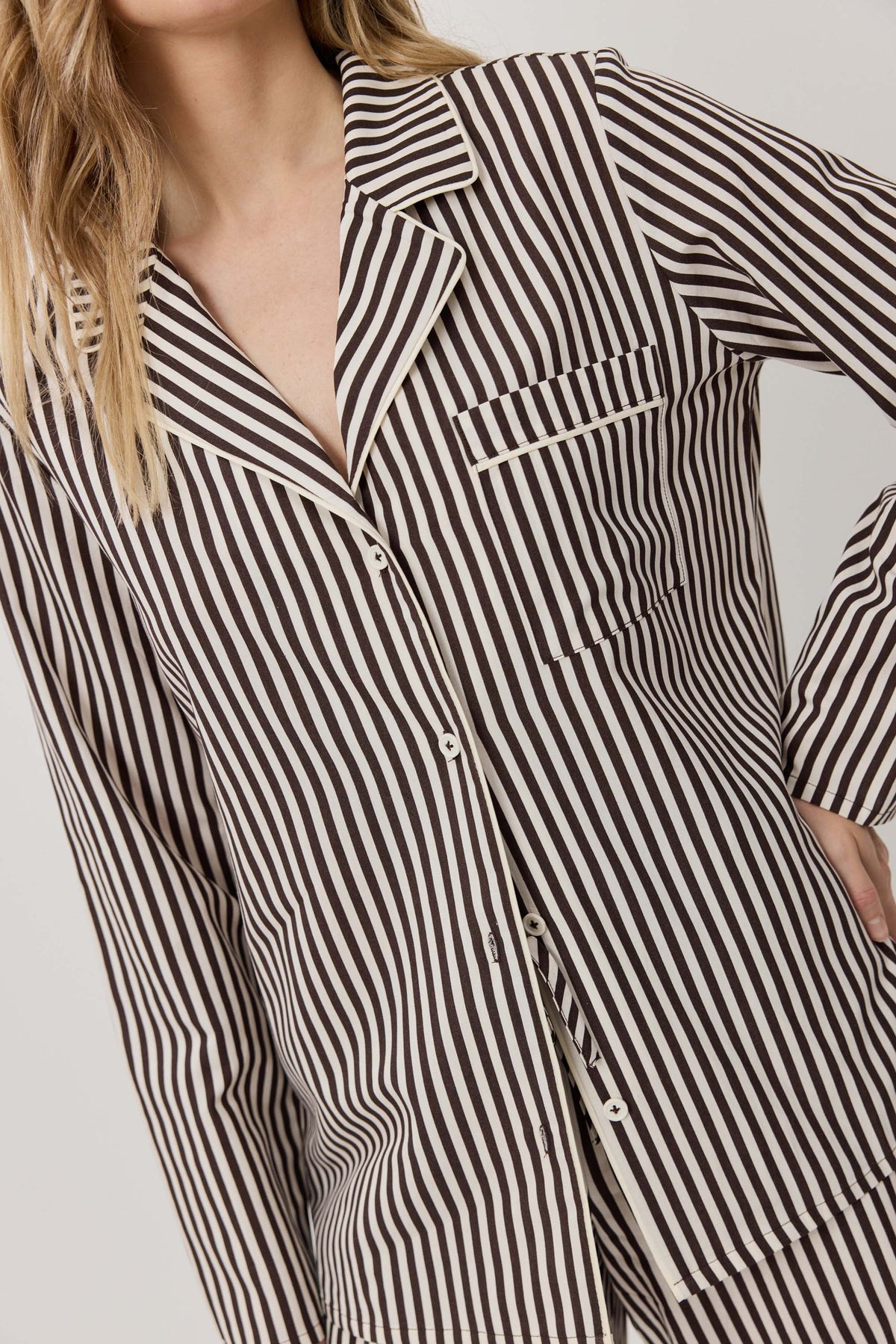 Black and white striped shirt worn by a person on a plain background