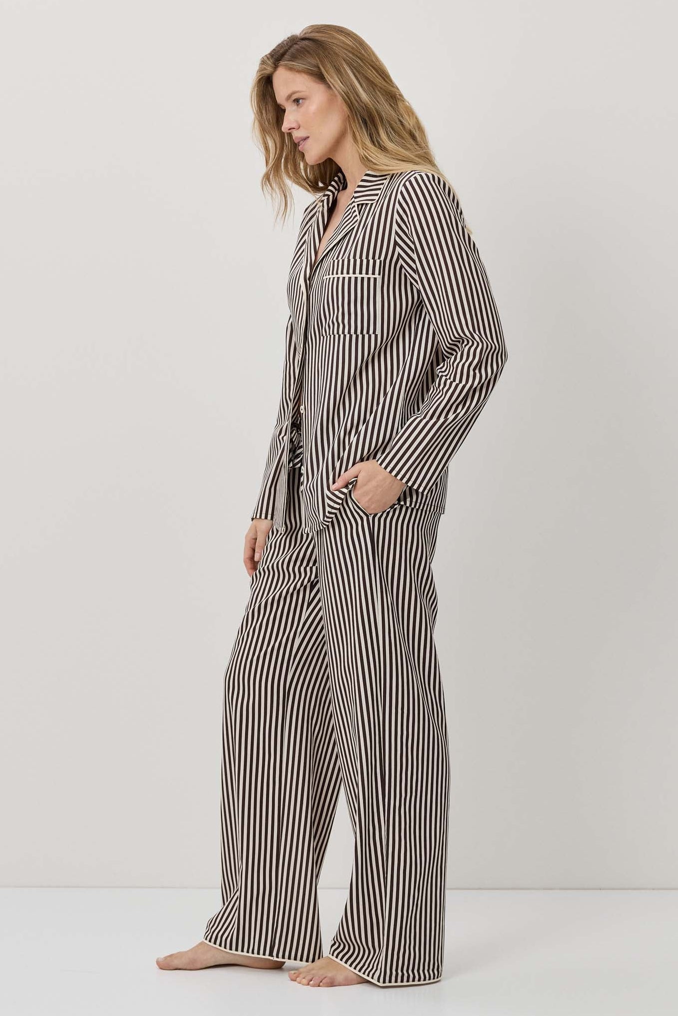 Woman wearing a striped pajama set on a white background