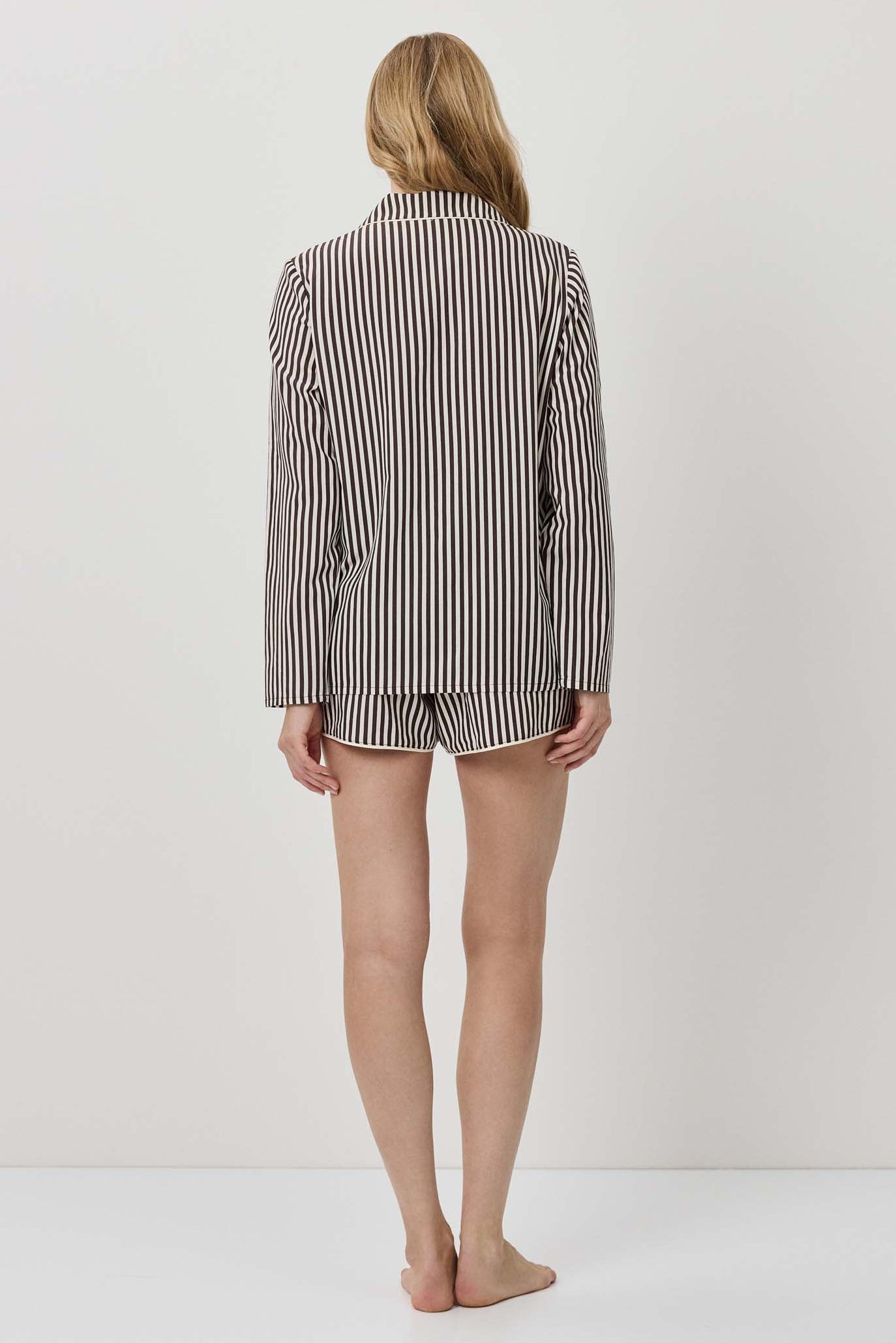 Person wearing a striped shirt and shorts on a plain background
