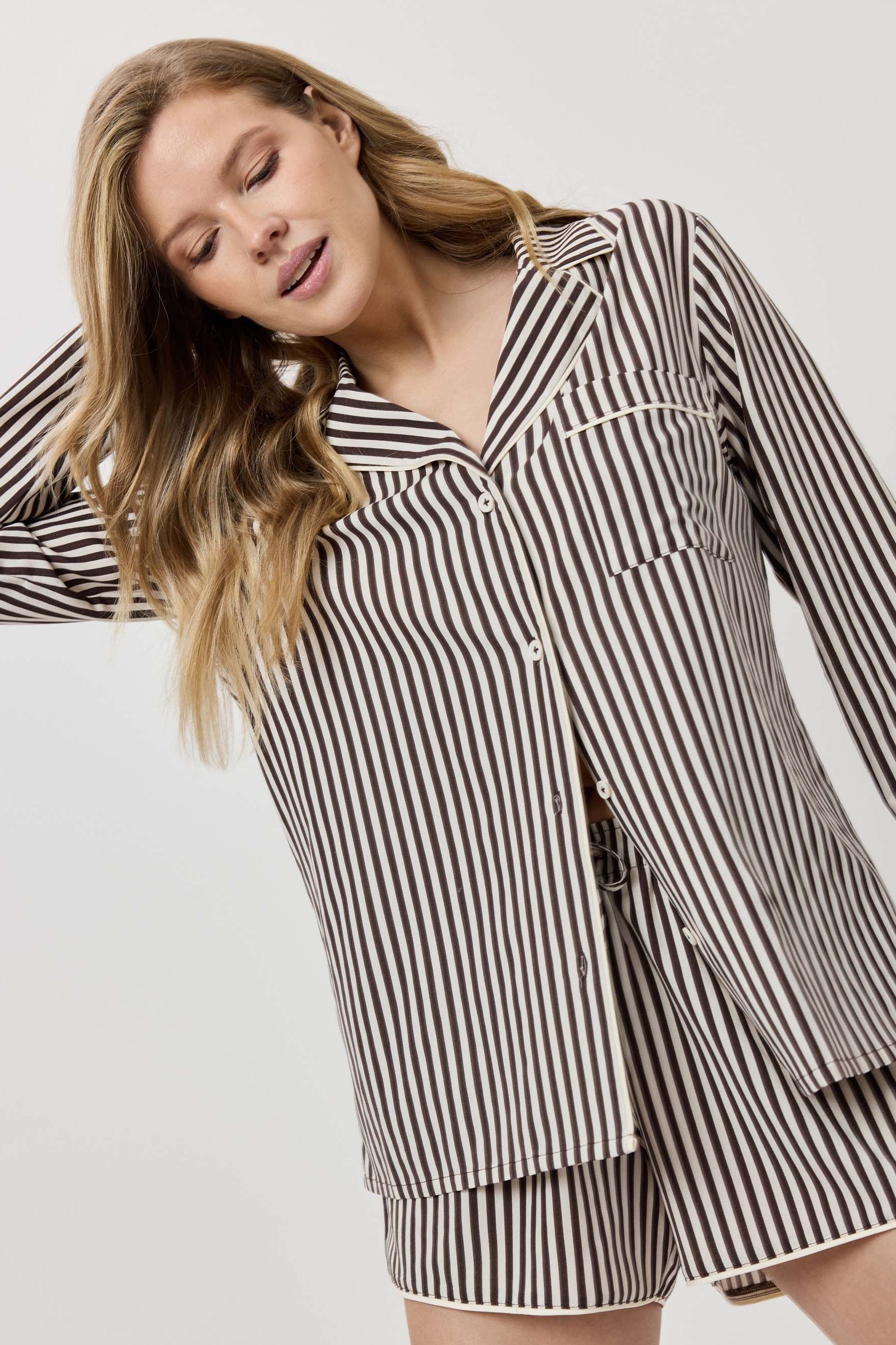 Woman wearing a black and white striped outfit on a plain background