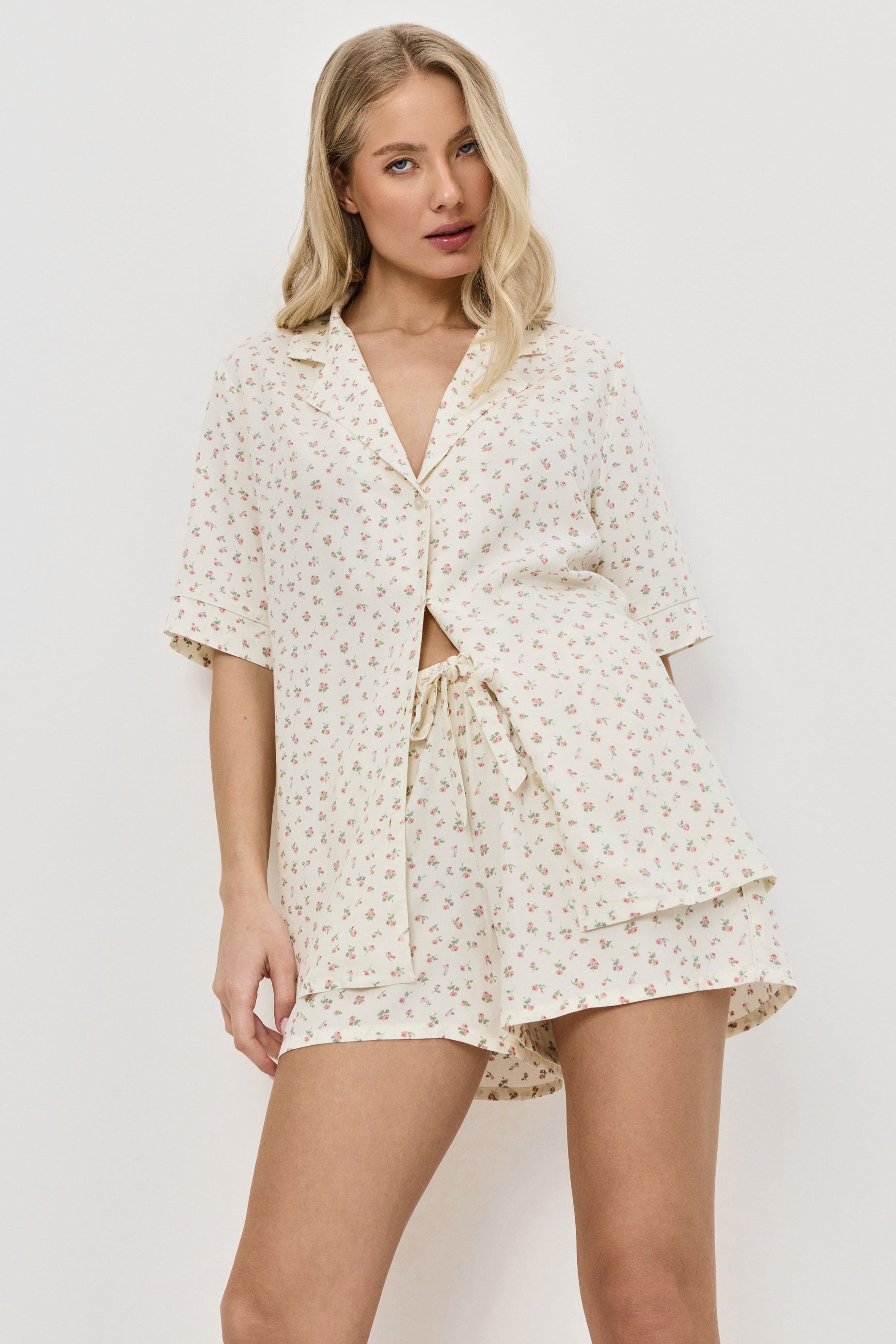 Woman wearing a floral pajama set against a white background