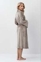 Woman wearing a capucine robe against a white background