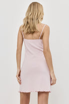 Woman wearing a light pink nightdress against a white background