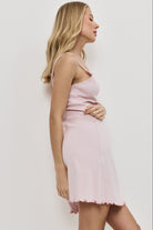 Woman wearing a light pink nightdress against a white background