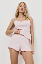 Woman wearing a pink pajama set against a white background