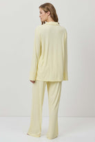 Woman wearing a light yellow outfit on a white background