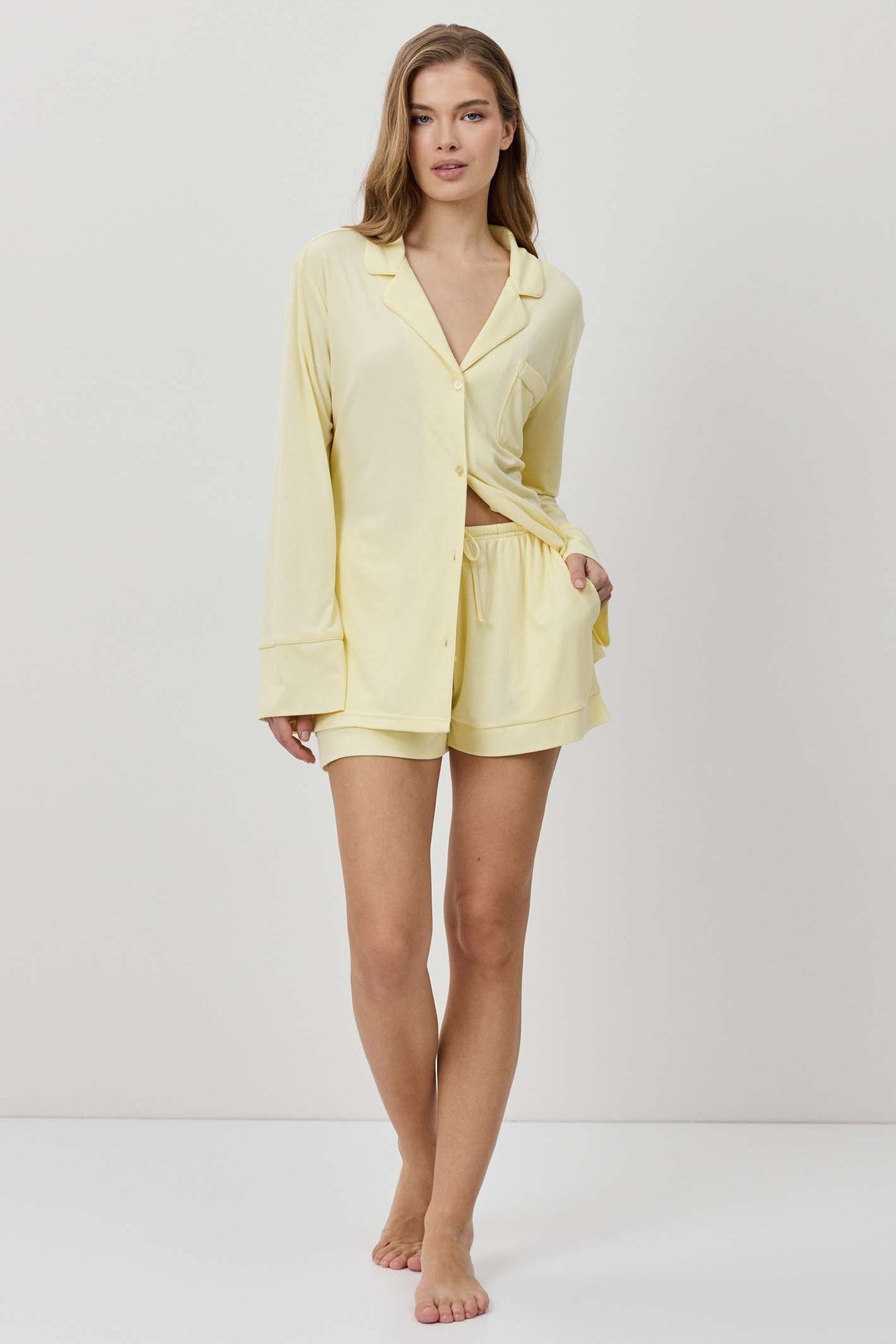 Woman wearing a light yellow robe and shorts on a white background