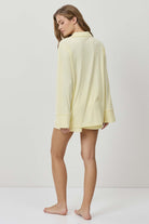 Woman wearing a light yellow dress against a white background
