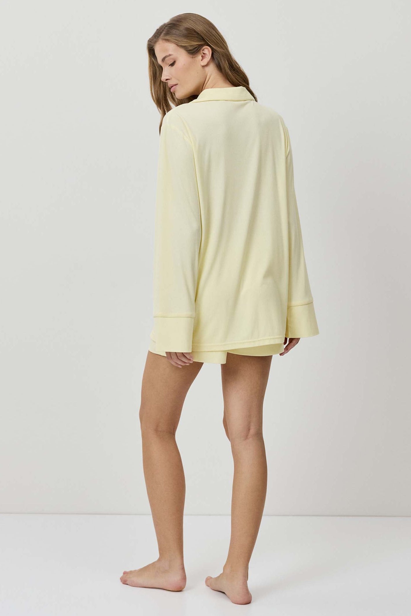 Woman wearing a light yellow dress against a white background