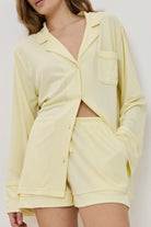 Woman wearing a light yellow lounge set against a white background
