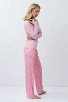 Woman wearing pink pajamas with a white background