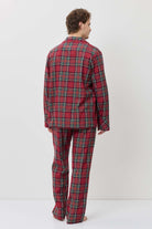 Person wearing a red plaid pajama set against a white background