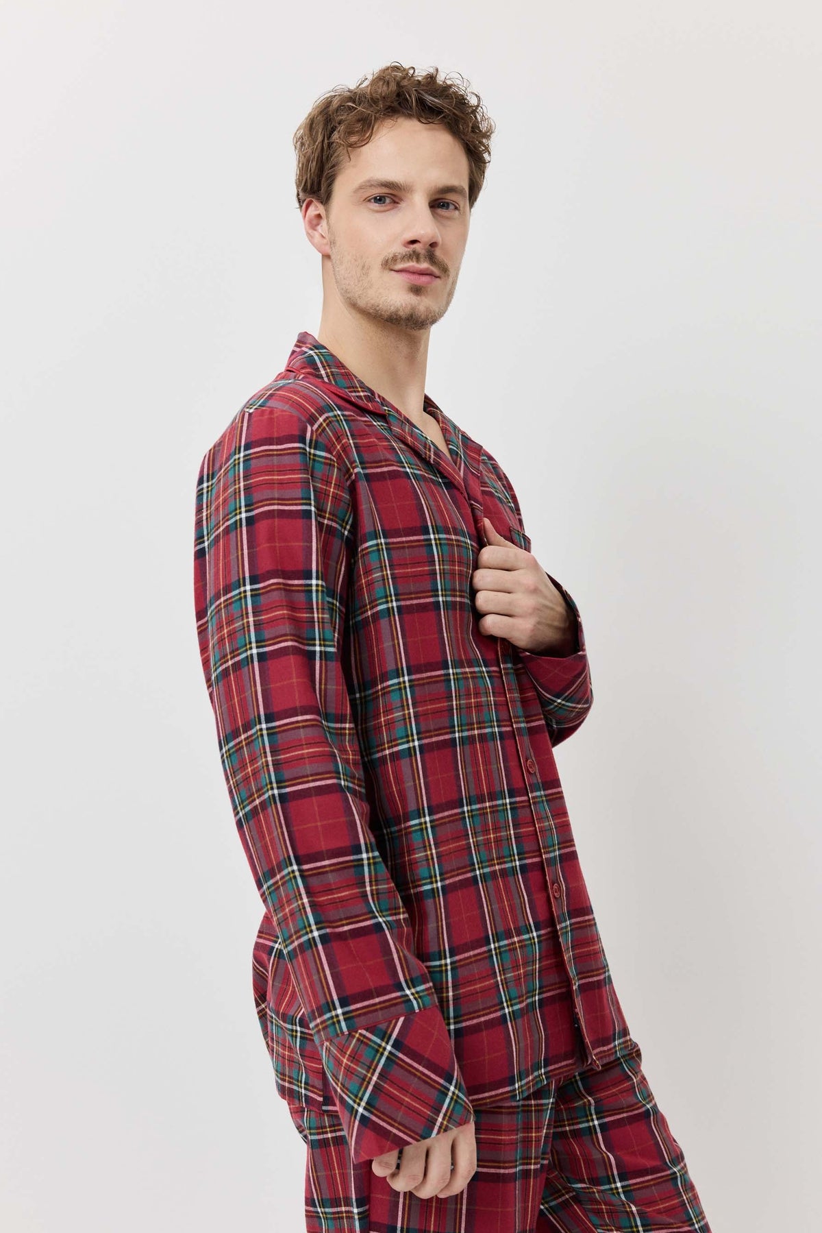 Man wearing a red plaid pajama set against a white background