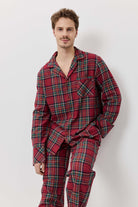 Man wearing red plaid pajamas against a white background