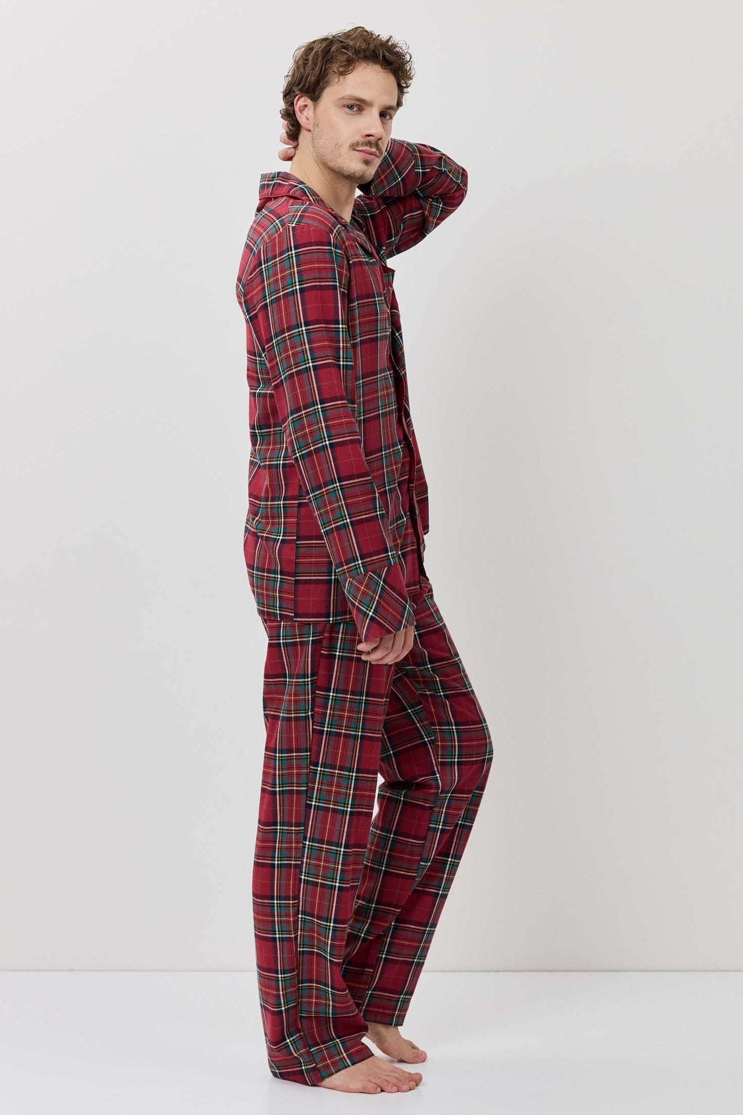 Person wearing a red plaid pajama set against a white background