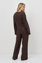 Woman wearing a brown resort wear set against a white background