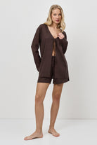 Woman wearing a brown resort wear set on a white background