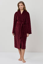 Woman wearing a burgundy robe on a white background