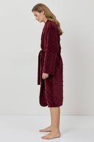 Woman wearing a burgundy robe on a white background