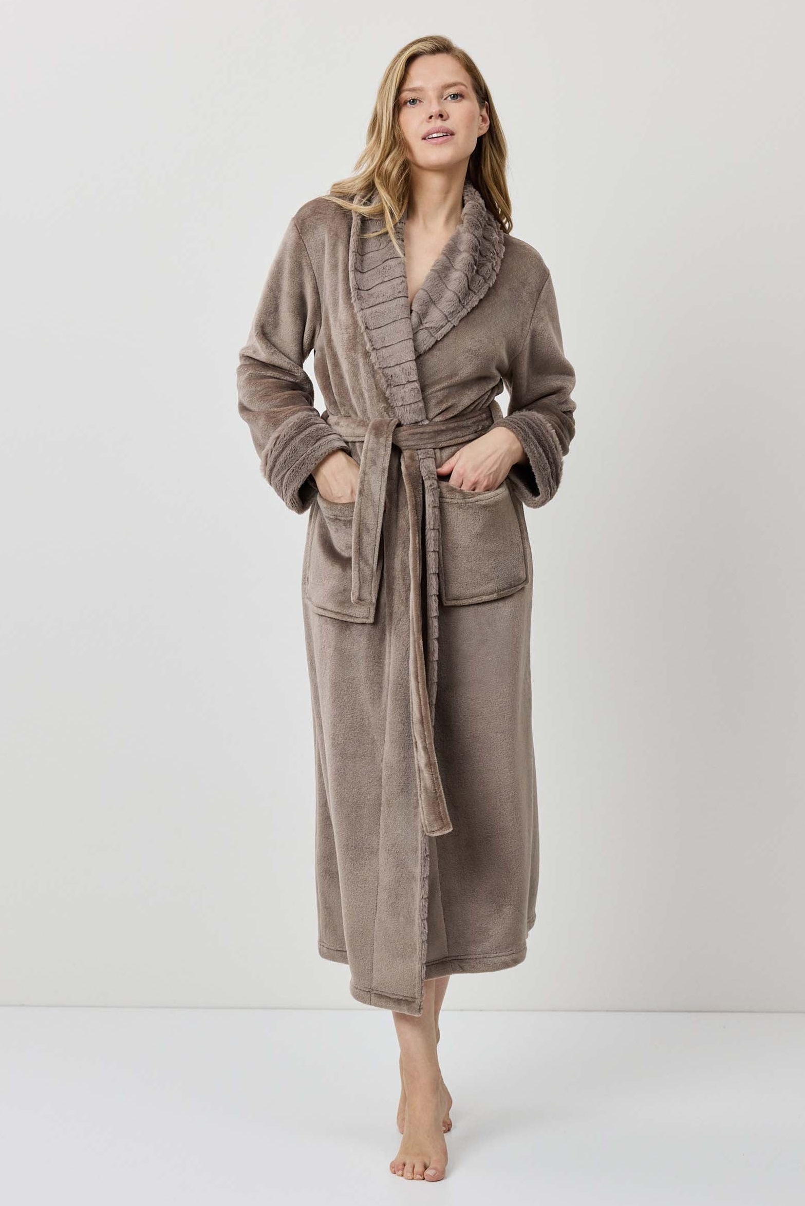 Woman wearing a brown robe against a white background