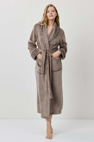 Woman wearing a brown robe against a white background