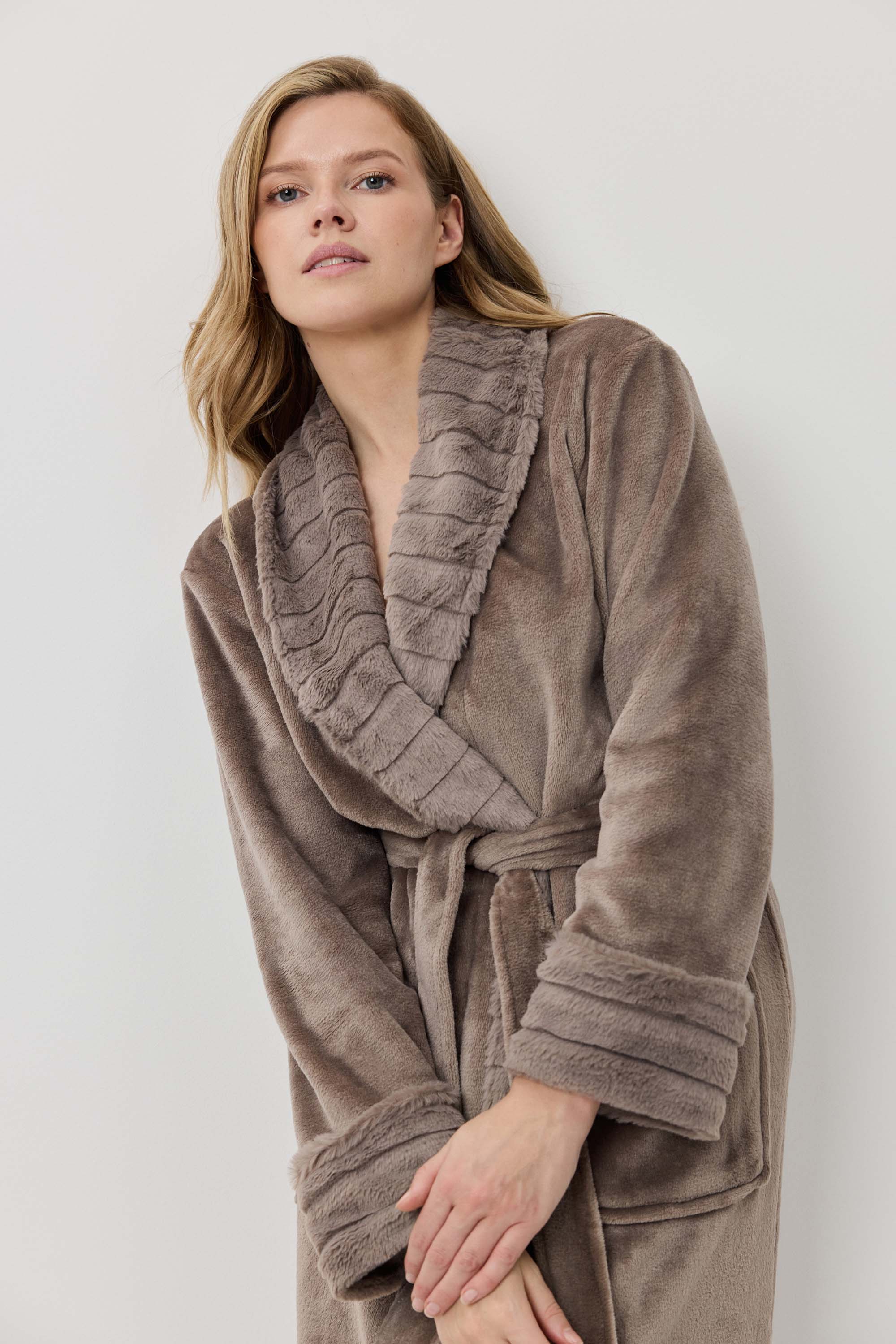 Woman wearing a brown robe against a white background