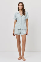 Woman wearing a light blue pajama set on a white background