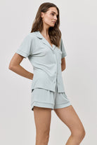 Woman wearing a light blue pajama set on a white background